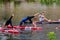 A group of young girls in the middle of the river perform sports exercises on swimming boards.