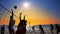 Group of young girls playing beach volleyball during sunset