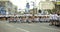 Group of young girls in sailor vests sitting on asphalt repeating figures before flash mob, other groups in white