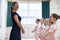 Group Of Young Girls With Teacher In Ballet Dancing Class