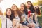 Group of young happy carefree girls friends making selfie on summer city street, sunset time background