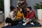 Group of young happy cheerful people with decorated Christmas tree gathered on small Christmas party in their home to celebrate