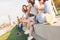 Group of young happy girls friends enjoy life on summer city street, sunset background