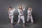 Group of young karate players doing kata on the gray background