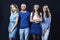 Group of young people in denim clothes on a black background