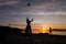 Group of young people playing beach volleyball silhouetted against the sunset at Kits Beach in Vancouver, BC.