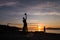 Group of young people playing beach volleyball silhouetted against the sunset at Kits Beach in Vancouver, BC.