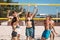 Group of young people playing volleyball on the beach