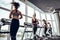 Group of young people running on treadmills in modern sport gym