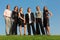 Group of young people stand on meadow