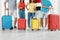 Group of young people with suitcases in light room