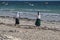 Group of young people walking along the beach on sunset background. Students and there parents going home.