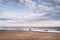 A group of young people watch the waves on Ramsgate main sands beach on a windy winter day in Kent