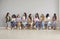 Group of young professional business women sitting on chairs in row and talkinng.