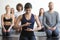 Group of young sporty people in vajrasana pose, rear view