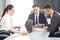 Group of young successful businessmen lawyers communicating together in a conference room while working on a project