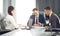 Group of young successful businessmen lawyers communicating together in a conference room while working on a project