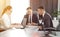 Group of young successful businessmen lawyers communicating together in a conference room while working on a project