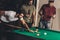 group of young successful handsome men playing in pool