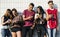 Group of young teenager friends chilling out together using smartphone social media concept