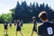 Group of young teenagers people in team wear playing a frisbee game in park oudoors. man tosses a frisbee to a teammate in an