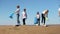 Group of young volunteers collects trash for recycling on beach on summer day spbi.