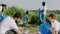 Group of young volunteers multiethnic beside on the lake on the big beach cleaning up the beach collecting the rubbish