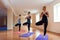 A group of young women performs asana tree of yoga