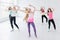 Group of young women posing with arms raised while having a fitness dance class