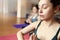 Group of young women relax in meditation in yoga class. Close up. Tint