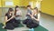 Group of young women in sportswear actively using phones. Four girl sitting on the mat totally focused on their smartphones