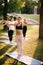 Group of young women are standing yoga pose with their hands outstretched out