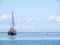 Group of youngsters wading in shallow water and sailboat aground