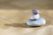 Group of zen stones pile, grey meditation pebbles tower on light brown wooden background in sunlight