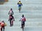 Groups of children with full suit of bicycle riding gear race each other riding the BMX