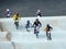 Groups of children with full suit of bicycle riding gear race each other riding the BMX