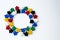 Groups of colorful meeples in circle isolated on gray background. Colorful round frame of game components. Small figures of man.