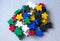 Groups of colorful meeples components of game on gray. Small figures of man. Board games concept. Happiness and fun