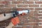 Grouting decorative gypsum brick with white cement grout. Applying grout with a syringe