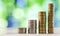 Growing coins stacks with green and blue sparkling bokeh background. Financial growth, saving money, business finance wealth and