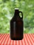 Growler at on Red Checkered Tablecloth against Blurry Trees