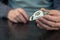 A grown man holds in his lower roller for a sliding door. Metal mounting plate with white plastic roller. Furniture hardware.