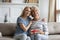 Grownup daughter greeting mom presenting gift package