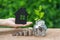 Growth sprout plant in jar with full of coins and hand holding p