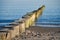Groynes protruding into the horizon in the Baltic Sea. Long exposure with muted colors