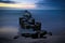 Groynes protruding into the horizon in the Baltic Sea. Long exposure with muted colors