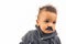 Grumpy stuffy multiracial baby boy in black fake moustache over white background.