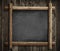 Grunge blackboard hanging on wooden wall background