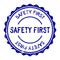 Grunge blue safety first word round rubber stamp on white background