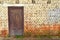 Grunge brick wall, old brickwork, A deteriorating old brick wall of an 18th century fort with wooden door. Retro vintage stone